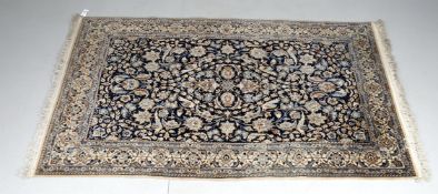 A Nain style rug with dark blue field with repeating bird and foliage decoration