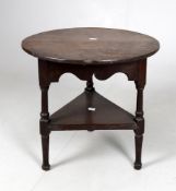 An oak circular occasional table with triangular form base