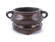 A large Chinese bronze incense burner and stand