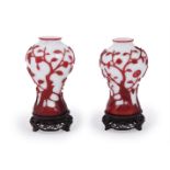 A pair of Chinese red overlay white Peking glass 'Bird and Peach Tree' vases
