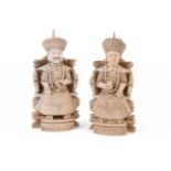 Y A pair of Chinese ivory figures modelled as a seated official and wife
