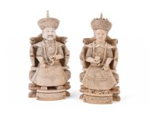 Y A pair of Chinese ivory figures modelled as a seated official and wife