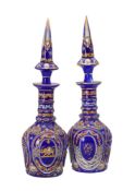 A pair of clear, opaque-white, and blue glass overlay decanters with spire shaped stoppers