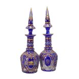 A pair of clear, opaque-white, and blue glass overlay decanters with spire shaped stoppers