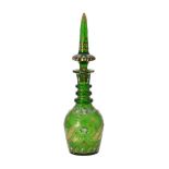 A green cut glass decanter and spier shaped stopper