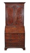 A George III mahogany bureau bookcase, the panel doors enclosing adjustable shelves, ...