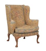 A walnut and tapestry upholstered wing armchair in George II style