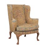 A walnut and tapestry upholstered wing armchair in George II style