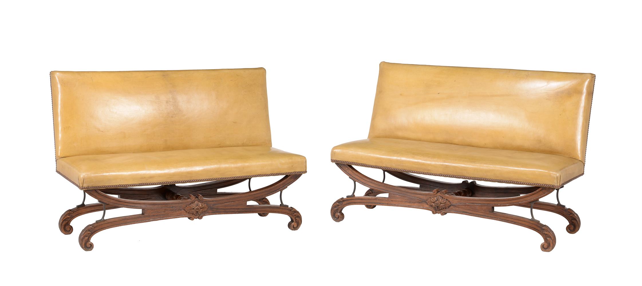 A pair of French carved oak and leather upholstered seats
