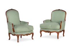 A near pair of Louis XV carved walnut and turquoise upholstered bergere armchairs