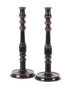 A pair of turned walnut and ebonised candlesticks