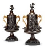 A PAIR OF PATINATED METAL AND SERPENTINE MARBLE MOUNTED 'ANIMALIER' URNS