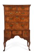 A GEORGE I WALNUT AND FEATHER BANDED CHEST ON STAND, CIRCA 1720