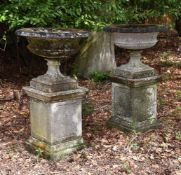 A PAIR OF COMPOSITION STONE URNS ON PEDESTALS, 20TH CENTURY