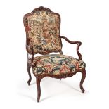 A LOUIS XV CARVED WALNUT AND NEEDLEWORK UPHOLSTERED ARMCHAIR, MID 18TH CENTURY