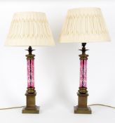 A pair of contemporary table lamps with etched cranberry glass columns