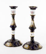 A pair of 19th century enamel candlesticks decorated with Watteauesque panels