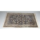 A Nain style rug with dark blue field with repeating bird and foliage decoration