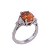 A three stone spessartine garnet and diamond ring by Theo Fennell