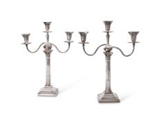 A pair of late Victorian silver three light Corinthian column candelabra