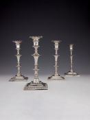 A set of four early George III cast silver square candlesticks by Ebenezer Coker