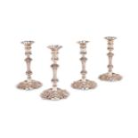 A SET OF FOUR GEORGE IV CAST SHAPED CIRCULAR CANDLESTICKS BY TIMOTHY SMITH & THOMAS MERRYWEATHER