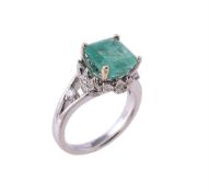 An emerald and diamond dress ring