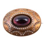 A mid Victorian garnet and enamel oval brooch