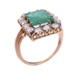 An emerald and diamond cluster ring