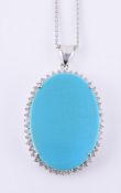 A reconstituted turquoise and diamond cluster pendant