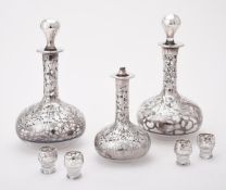 A set of three silver coloured overlaid glass bottles and stoppers