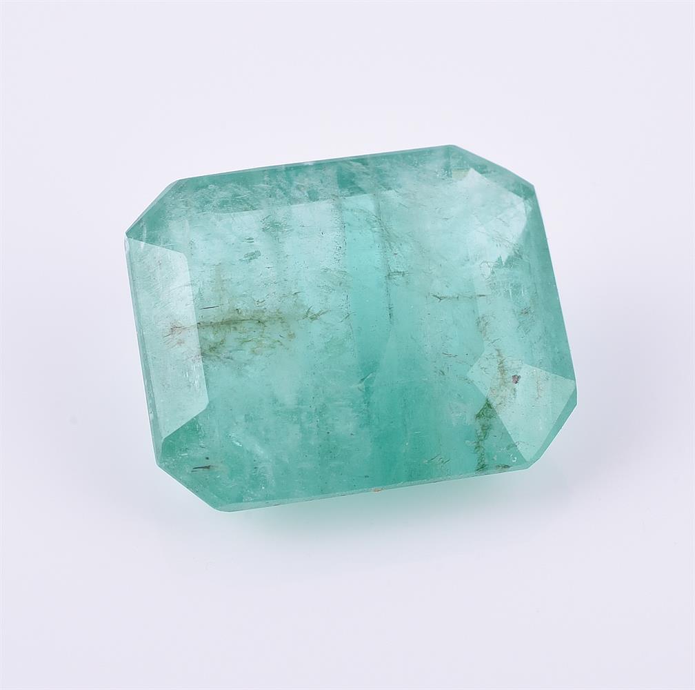 † An unmounted step cut emerald with canted corners