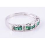 An emerald and diamond band ring