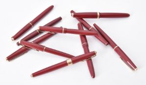 A collection of ten red Parker fountain pens
