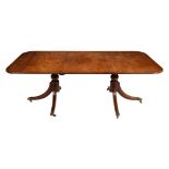 A mahogany twin pedestal dining table with one loose leaf in Regency style