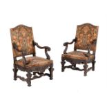 A pair of carved walnut and upholstered armchairs in mid 18th century style