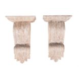 A pair of carved and white painted wood wall brackets