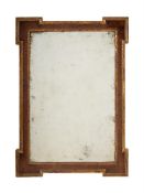 A GEORGE II WALNUT AND PARCEL GILT WALL MIRROR, IN THE MANNER OF WILLIAM KENT