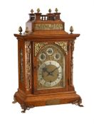 AN EDWARDIAN GILT BRASS MOUNTED OAK QUARTER-CHIMING BRACKET CLOCK