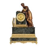 A FRENCH EMPIRE ORMOLU AND VERDE ANTICO MARBLE FIGURAL MANTEL CLOCK