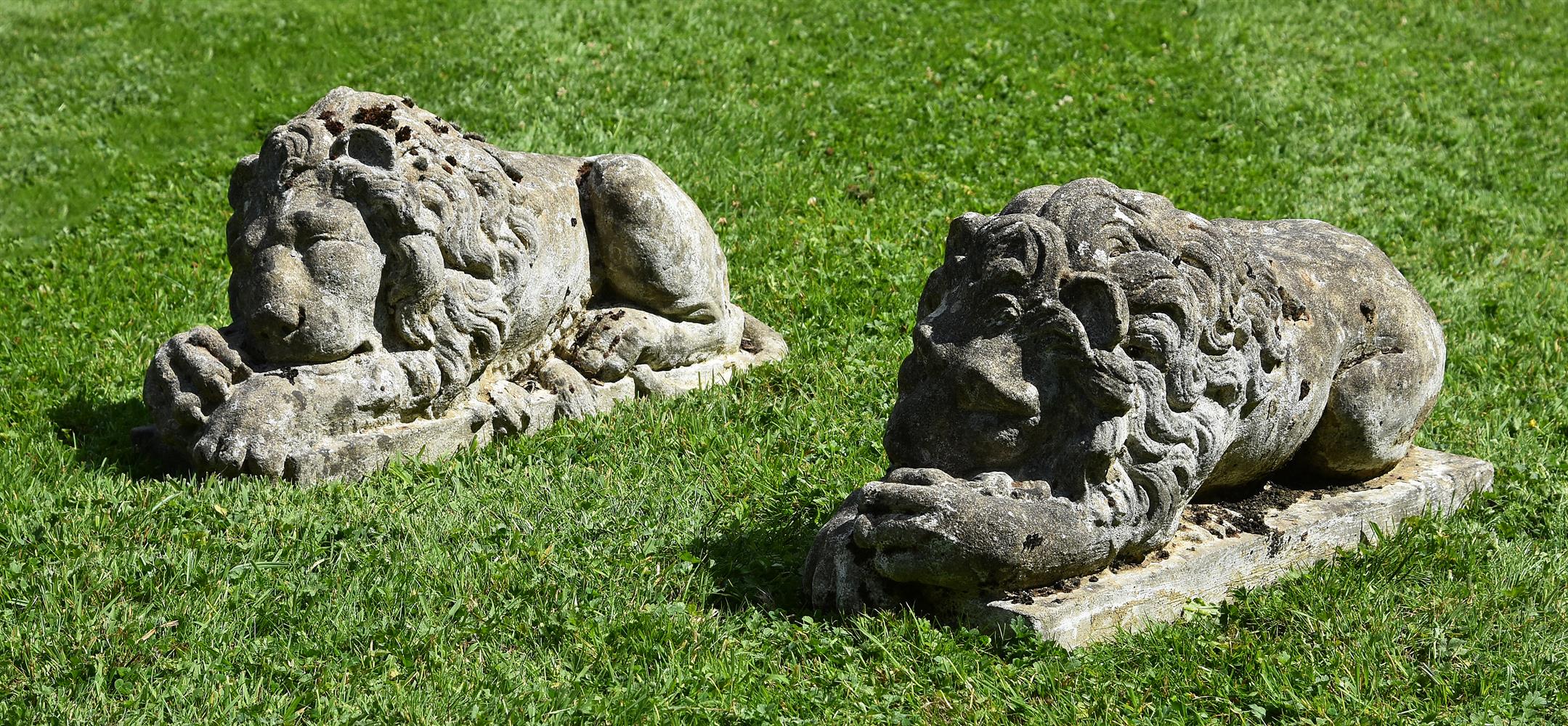 A PAIR OF COMPOSITION STONE MODELS OF RECUMBENT LIONS, 20TH CENTURY