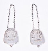 A pair of silver armorial bottle or decanter labels by Roberts & Belk Ltd