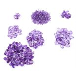 † A large packet of oval and circular cut amethysts
