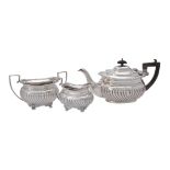 An Edwardian silver three piece oblong half lobed tea set by George Nathan & Ridley Hayes