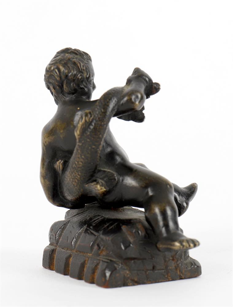 A small bronze of a seated child wrestling a dolphin and a bronze figural seal - Image 2 of 11