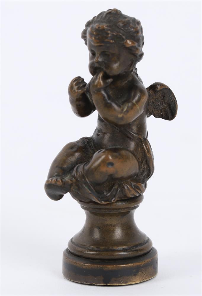 A small bronze of a seated child wrestling a dolphin and a bronze figural seal - Image 5 of 11