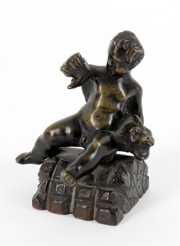 A small bronze of a seated child wrestling a dolphin and a bronze figural seal - Image 4 of 11