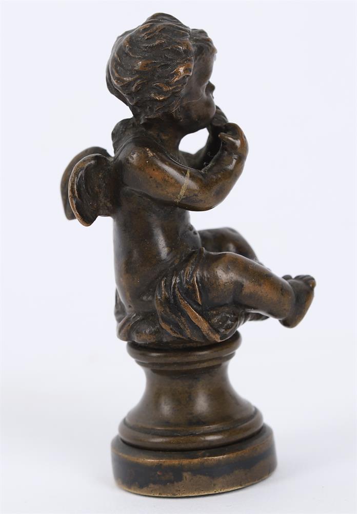 A small bronze of a seated child wrestling a dolphin and a bronze figural seal - Image 8 of 11