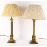 A pair of brass columnar lamps and shades