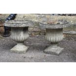 A pair of composition stone urns